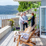 Zadovoljan par se rukuje sa agentom na terasi luksuzne kuće, istražujući nove mogućnosti za rast i profitabilnost kroz Raiffeisen Alternative investicioni fond